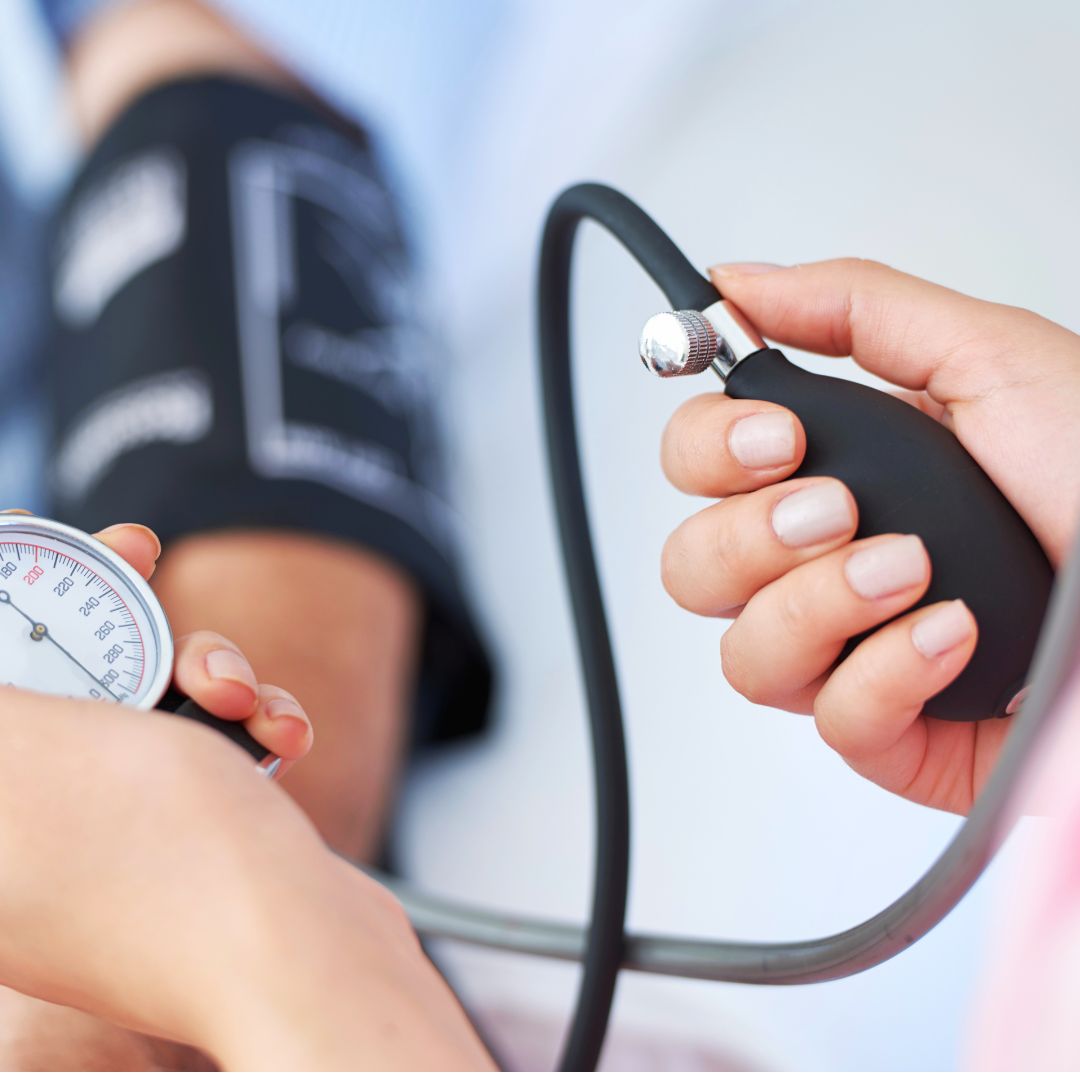 Up-close photo of a doctor taking a patient's blood pressure with an arm cuff.