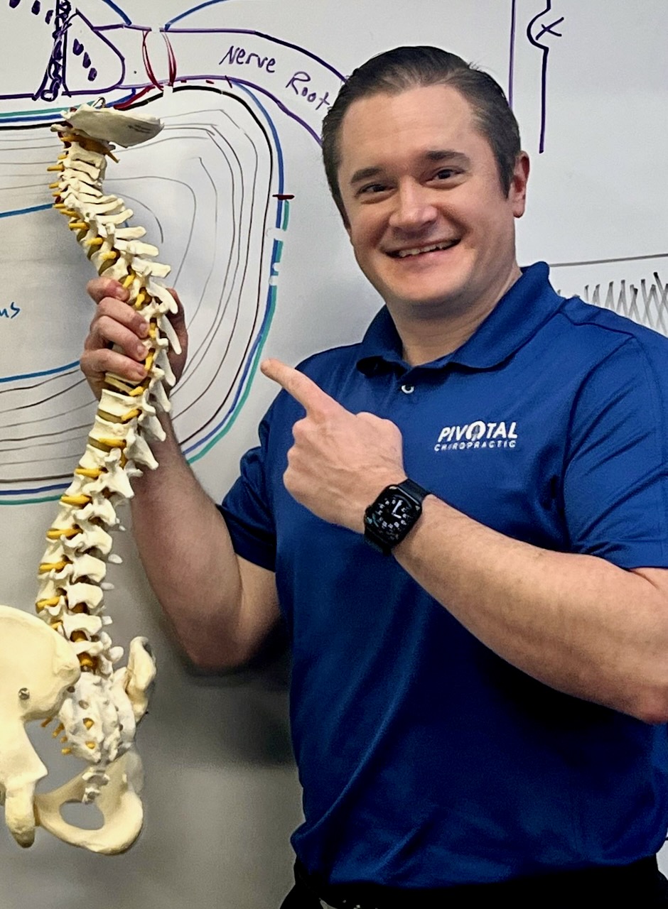 Photo of Dr. Gessert holding a model spine.